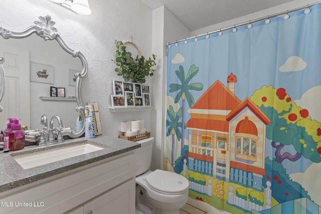 bathroom with vanity, a textured ceiling, and toilet