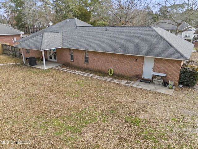 back of property with a yard and a patio area