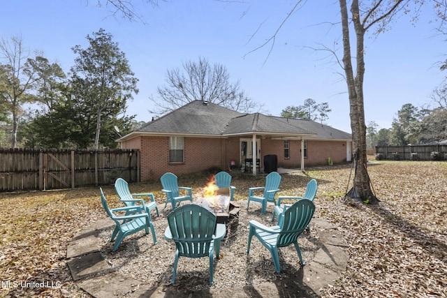 rear view of house with a patio and an outdoor fire pit