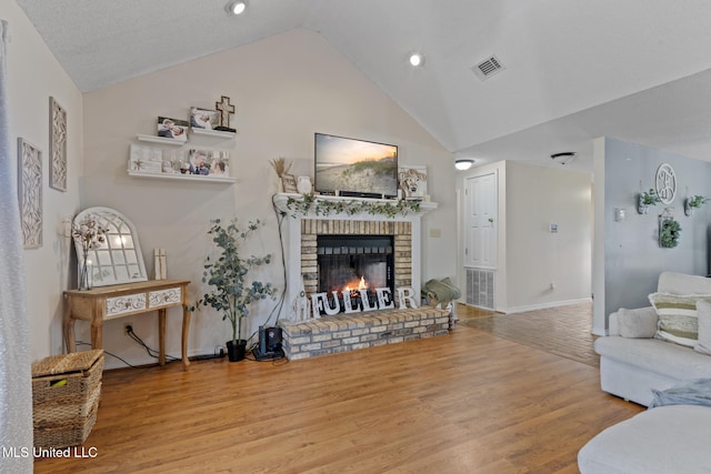 living room featuring high vaulted ceiling, hardwood / wood-style floors, and a fireplace