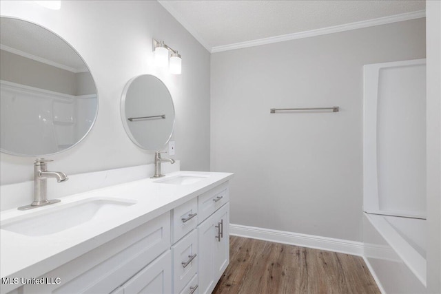 250 1st St, Webb, MS 38966 - bathroom with wood finished floors, ornamental molding, double vanity, and baseboards