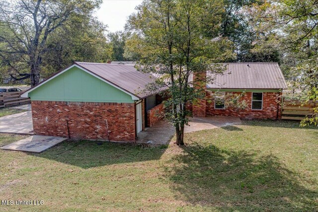 250 1st St, Webb, MS 38966 - view of side of home with brick siding, metal roof, and a patio