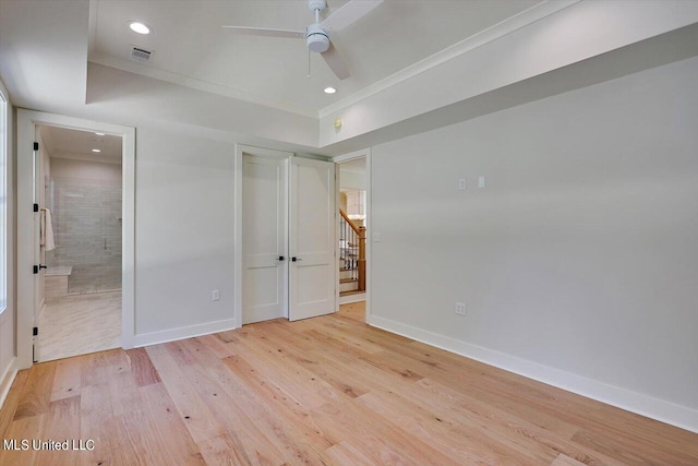 unfurnished bedroom featuring a closet, light hardwood / wood-style floors, ensuite bathroom, and ceiling fan