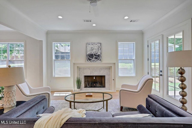 living room with hardwood / wood-style flooring, a wealth of natural light, and a high end fireplace