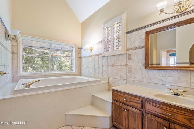 bathroom featuring vanity, a tub, a healthy amount of sunlight, and lofted ceiling