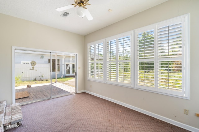 unfurnished sunroom with a wealth of natural light and ceiling fan