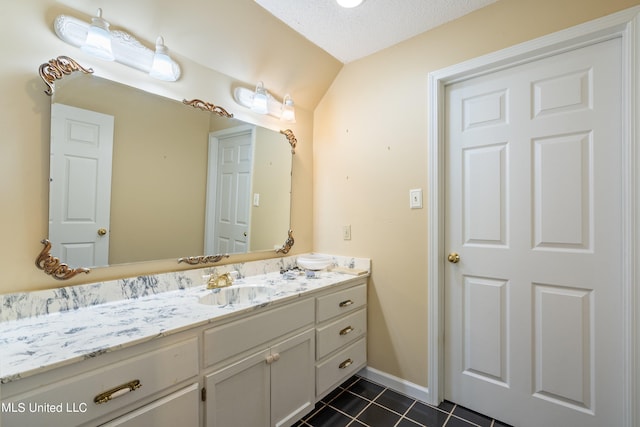 bathroom featuring vanity, a textured ceiling, lofted ceiling, and tile patterned flooring