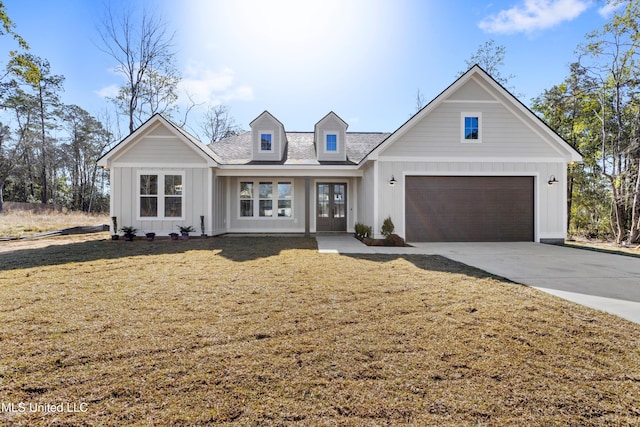 modern farmhouse with a garage, concrete driveway, a front lawn, and board and batten siding