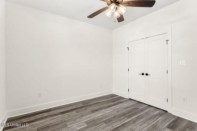 unfurnished bedroom with a closet, baseboards, and wood finished floors