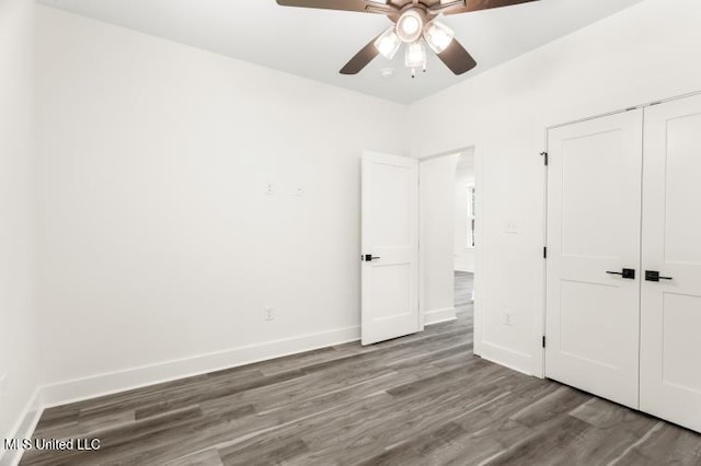 unfurnished bedroom with ceiling fan, a closet, wood finished floors, and baseboards