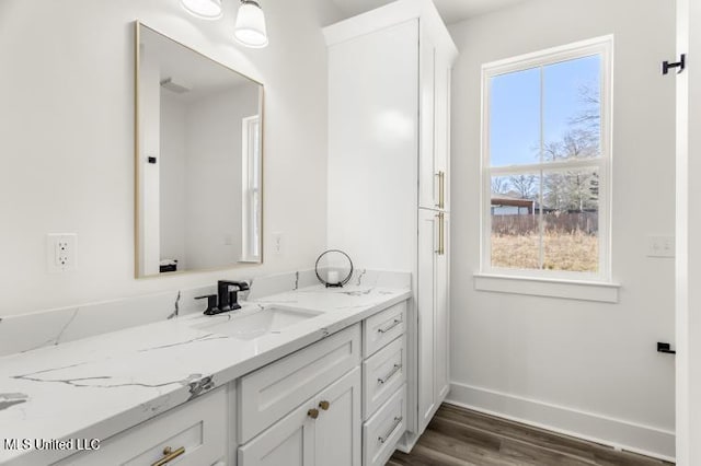 bathroom featuring plenty of natural light, wood finished floors, vanity, and baseboards