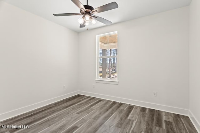 unfurnished room with dark wood-style floors, ceiling fan, and baseboards