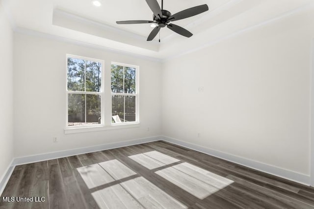 unfurnished room with recessed lighting, baseboards, dark wood-style floors, a raised ceiling, and crown molding