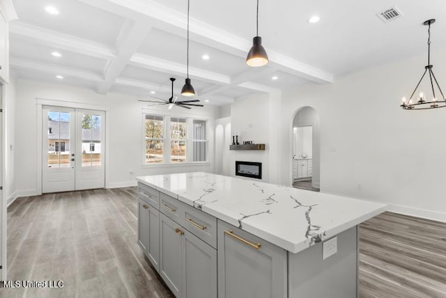 kitchen with gray cabinets, wood finished floors, and open floor plan