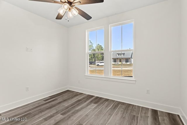 spare room featuring ceiling fan, baseboards, and dark wood finished floors