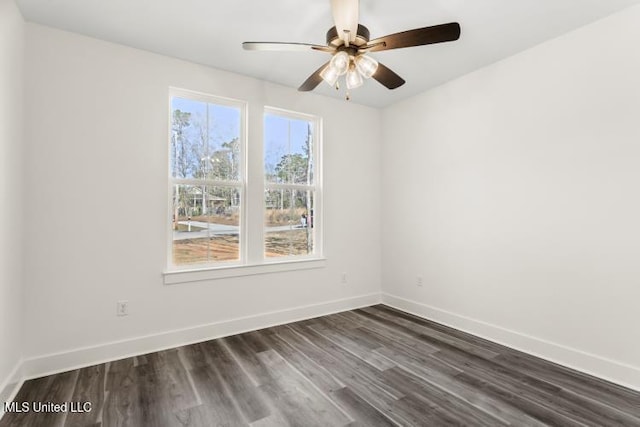 spare room with dark wood finished floors, baseboards, and ceiling fan