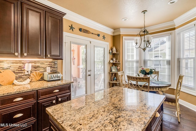 kitchen with dark hardwood / wood-style flooring, crown molding, french doors, and plenty of natural light