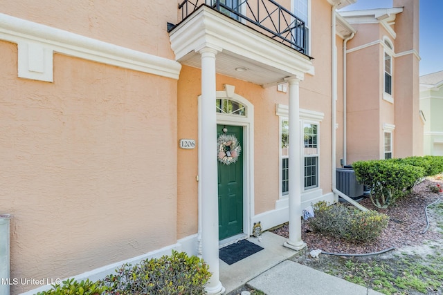 property entrance featuring a balcony and central air condition unit