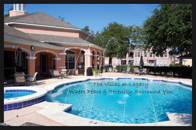 view of swimming pool featuring a patio and a hot tub