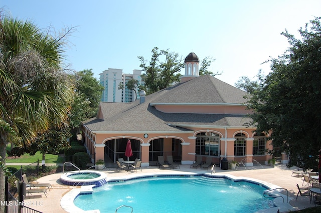 view of pool with pool water feature, a community hot tub, and a patio