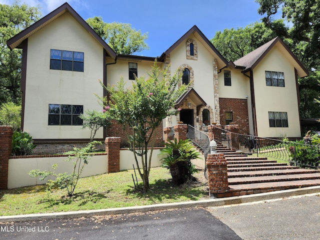 526 N 2nd St, Bay Saint Louis, MS 39520 - view of front facade with stucco siding, stairway, and brick siding