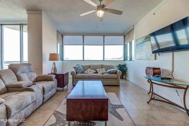 living room featuring light tile patterned floors, baseboards, a ceiling fan, and a textured ceiling