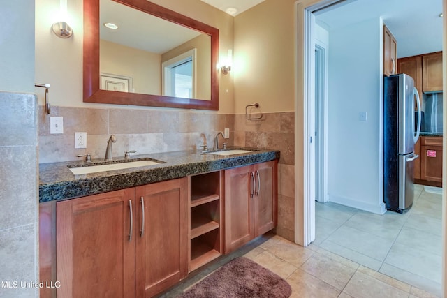 bathroom with double vanity, a sink, tile walls, and tile patterned floors