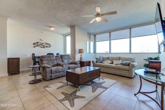 living room with light tile patterned floors, ceiling fan, baseboards, and a textured ceiling