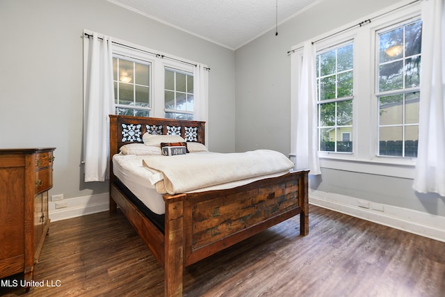 bedroom with dark wood-type flooring, ornamental molding, and a textured ceiling