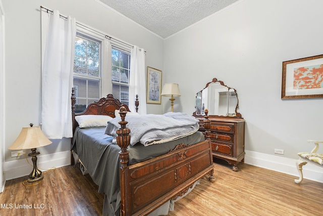 bedroom with crown molding, a textured ceiling, and light hardwood / wood-style floors