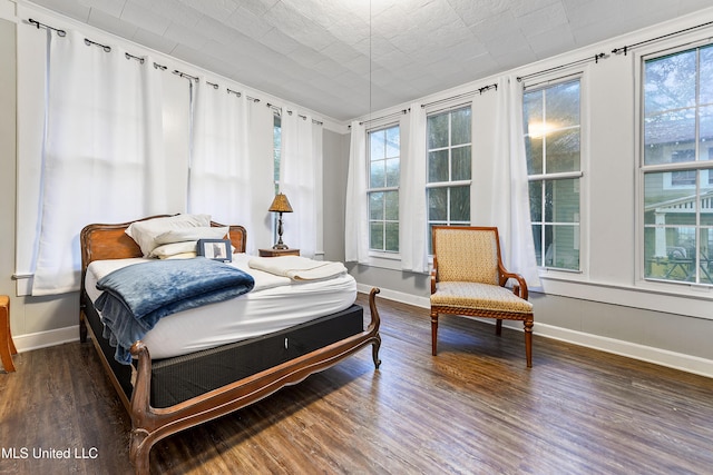 bedroom with dark wood-type flooring and multiple windows