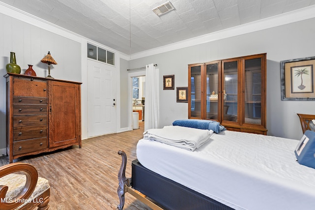 bedroom featuring light hardwood / wood-style flooring and ornamental molding