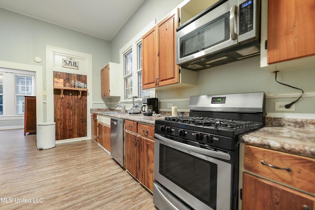 kitchen with stainless steel appliances, sink, and light hardwood / wood-style floors