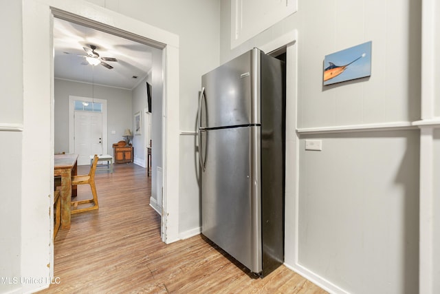 kitchen featuring stainless steel fridge, ornamental molding, ceiling fan, and light wood-type flooring