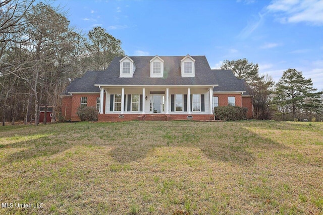 cape cod-style house with brick siding and a front lawn