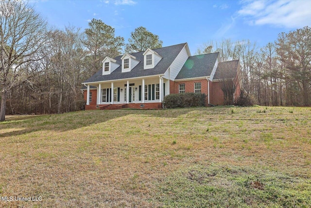 cape cod house with a porch, brick siding, and a front lawn