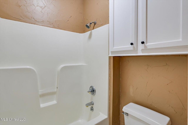 bathroom with bathing tub / shower combination and toilet