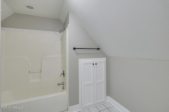 bathroom featuring lofted ceiling, shower / bath combination, tile patterned flooring, and baseboards