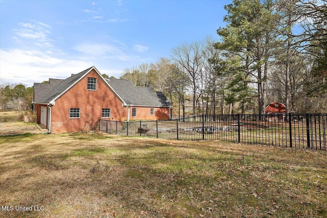 exterior space with a yard, fence, and brick siding