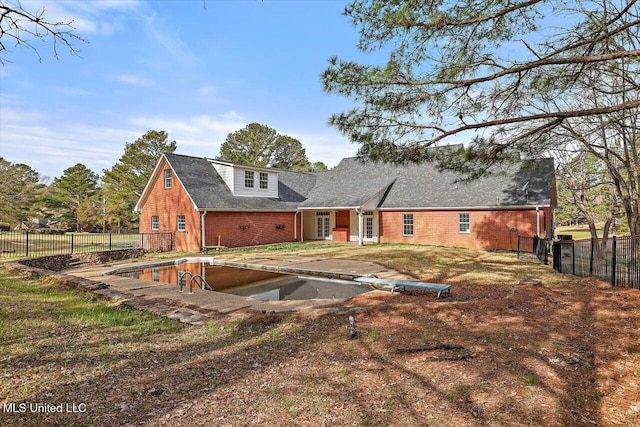 rear view of property with brick siding and fence