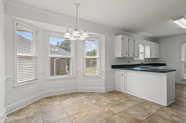 1035 N Azalea Dr, Madison, MS 39110 - kitchen with dark countertops, white cabinets, a chandelier, ornamental molding, and healthy amount of natural light