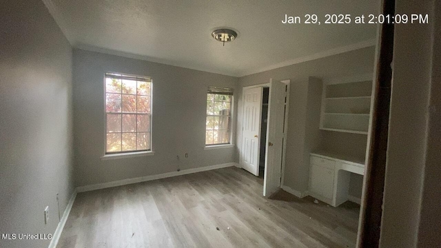 unfurnished bedroom with crown molding and light hardwood / wood-style floors