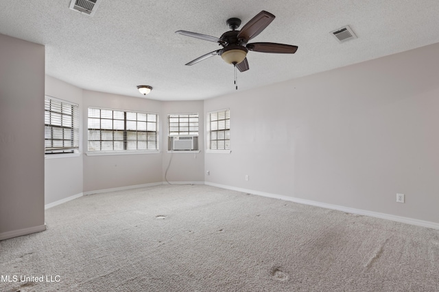 carpeted empty room featuring cooling unit, ceiling fan, and a textured ceiling