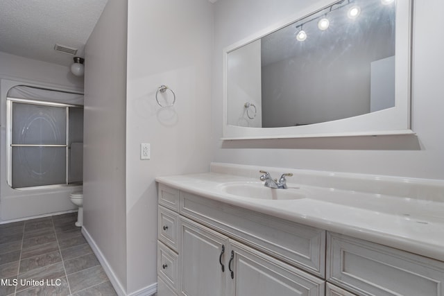 full bathroom with vanity, a textured ceiling, shower / bath combination with glass door, and toilet