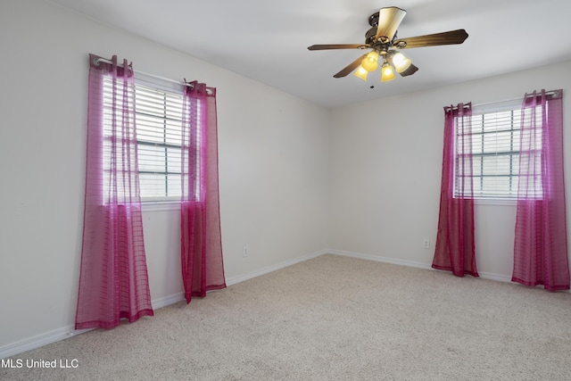 carpeted empty room with plenty of natural light and ceiling fan