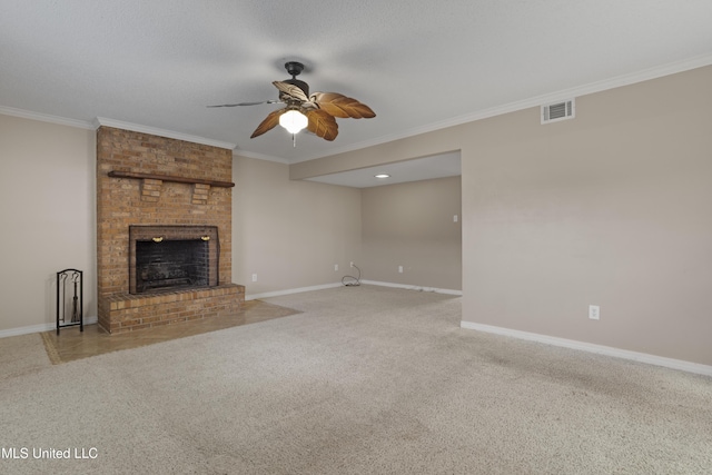 unfurnished living room with ceiling fan, ornamental molding, carpet floors, and a brick fireplace