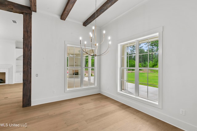 unfurnished dining area with beamed ceiling, a notable chandelier, a fireplace, and light hardwood / wood-style floors