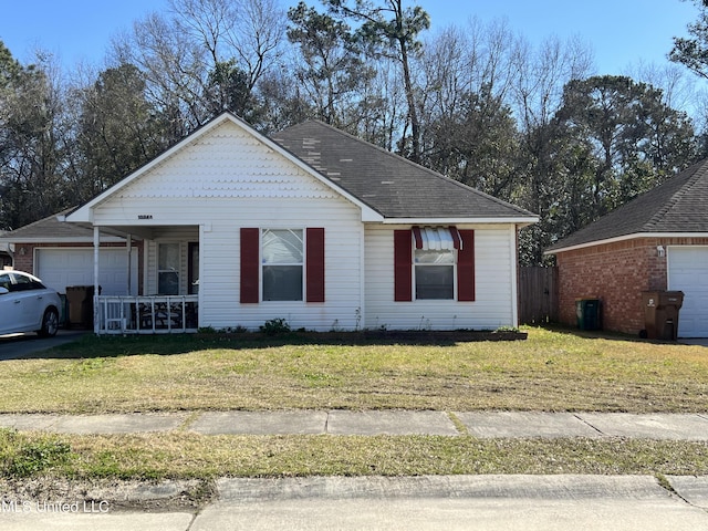 view of front of property featuring covered porch, a front yard, and a garage