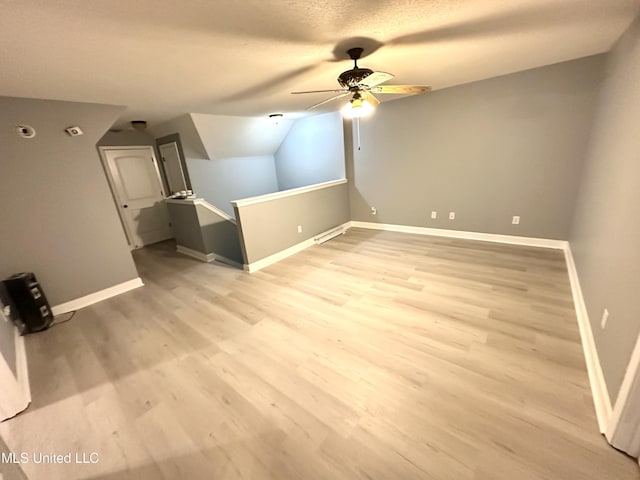 bonus room featuring a textured ceiling, ceiling fan, light hardwood / wood-style flooring, and lofted ceiling