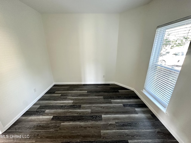 unfurnished room with dark hardwood / wood-style flooring